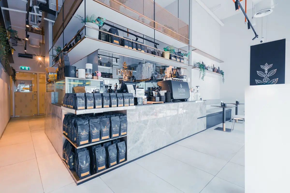 Inside a Boon café, bags of beans on the shelves