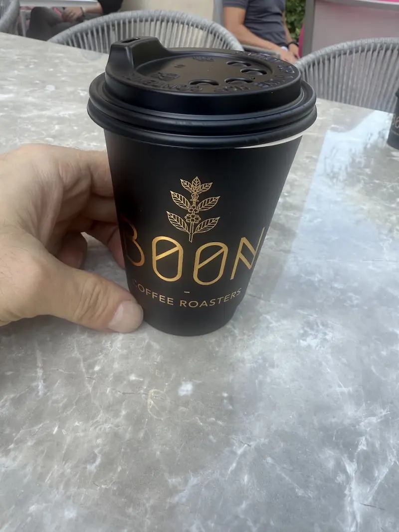 A Boon takeaway cup on a marble counter